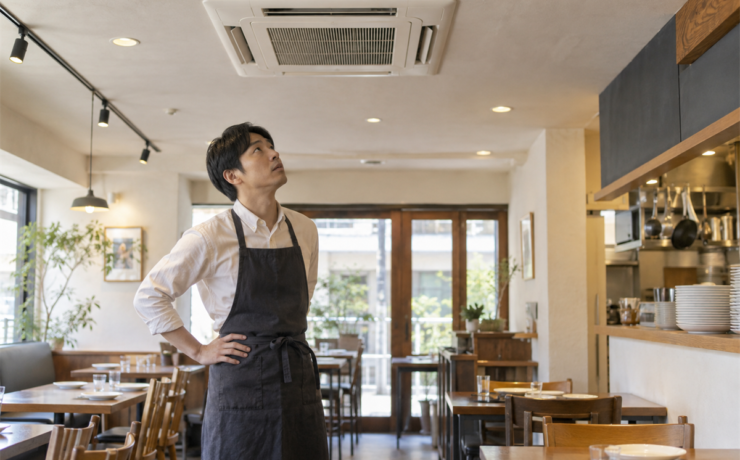 店舗で天井埋込形業務用エアコンの音を確認する担当者